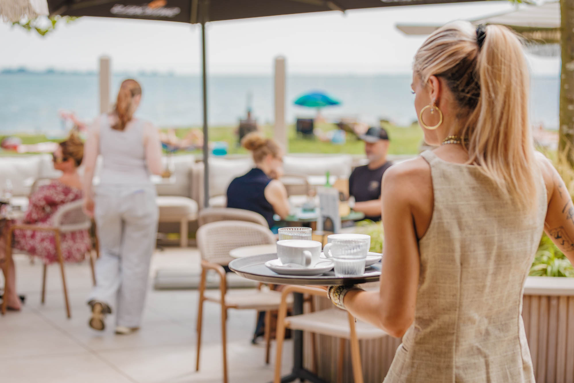 Bediening tussen de tafels op het terras van atMirror