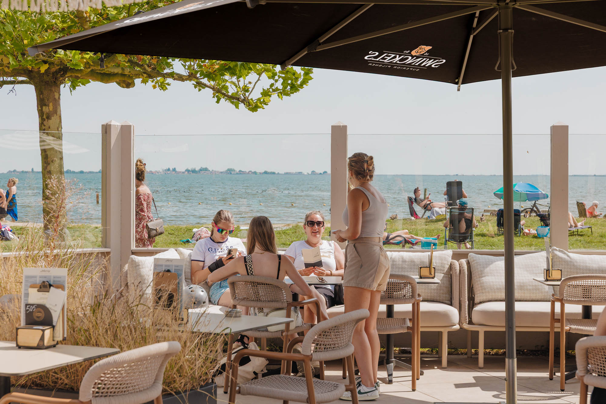 Gasten op het terras van atMirror met uitzicht op de Gouwzee