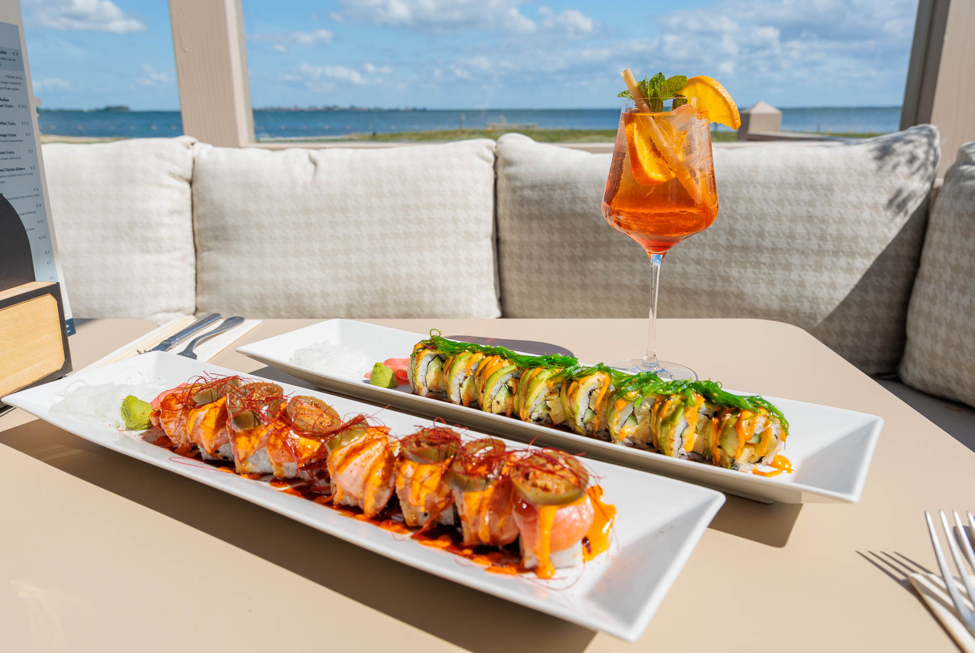 Planken met verse sushi en een spritz op het terras van atMirror